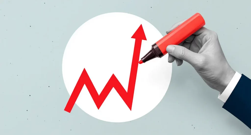 Main dessinant un graphique de croissance avec un marqueur rouge sur fond clair.