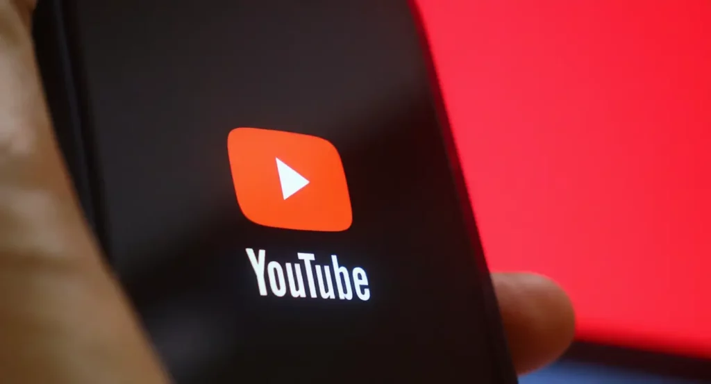 Logo de YouTube sur un écran noir, mettant en avant le symbole de lecture et le nom de la plateforme.