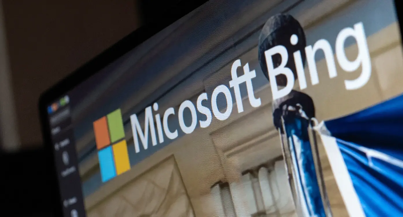 Logo de Microsoft Bing affiché sur un écran, avec des éléments graphiques colorés en arrière-plan.