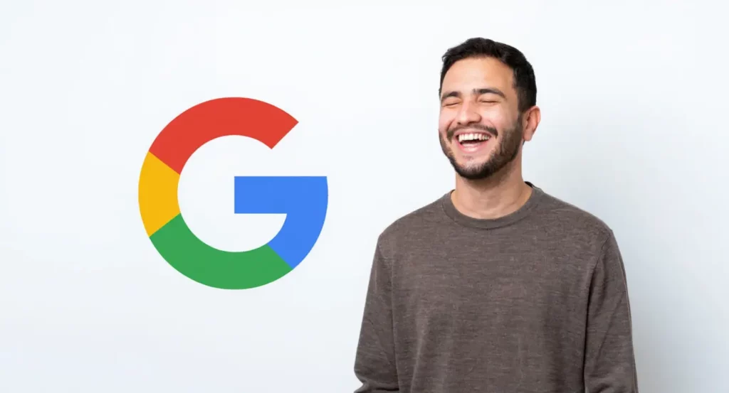 Homme souriant devant le logo coloré de Google sur un fond blanc, illustrant la convivialité de la marque.