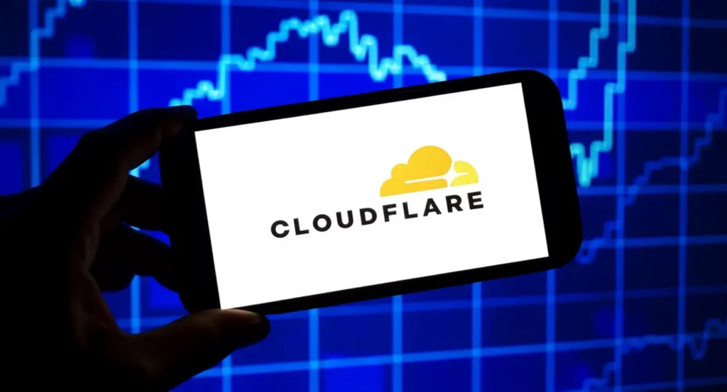 Logo de Cloudflare affiché sur un smartphone devant un graphique de données numériques en arrière-plan.