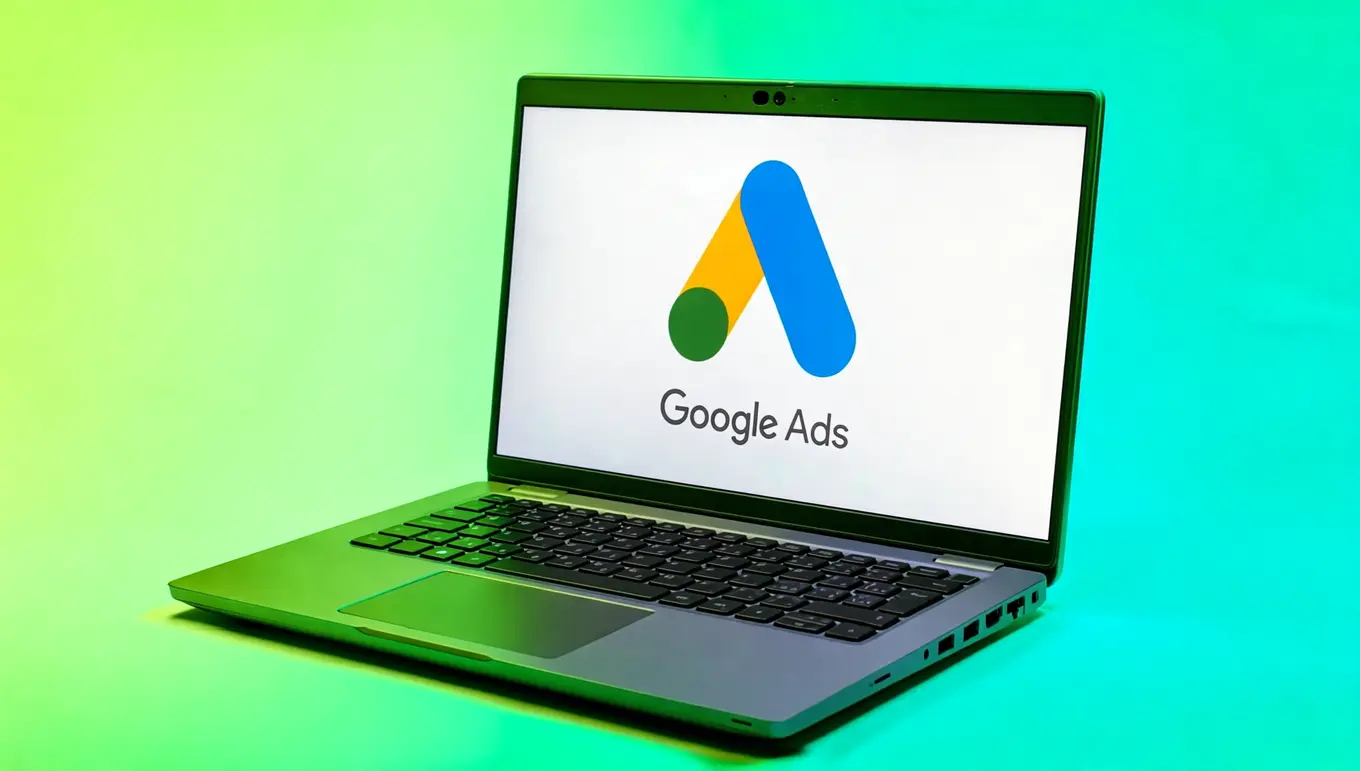 Ordinateur portable affichant le logo de Google Ads sur fond dégradé vert, illustrant le marketing numérique.