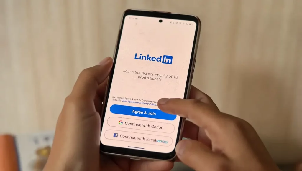 Écran de smartphone affichant l'application LinkedIn avec un bouton "Agree & Join" pour rejoindre une communauté professionnelle.