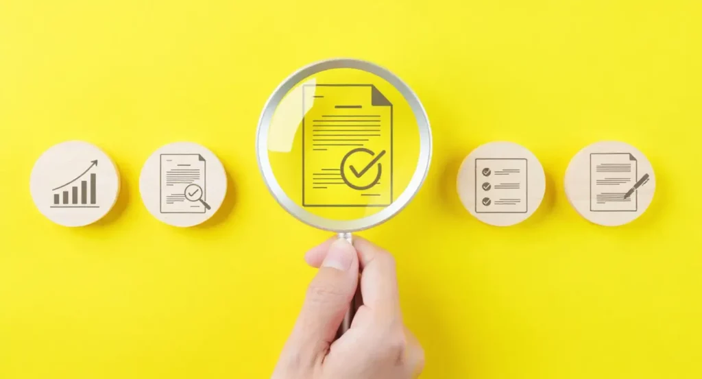 Document avec une coche examiné sous une loupe, sur fond jaune, entouré d'icônes de graphiques et de notes.