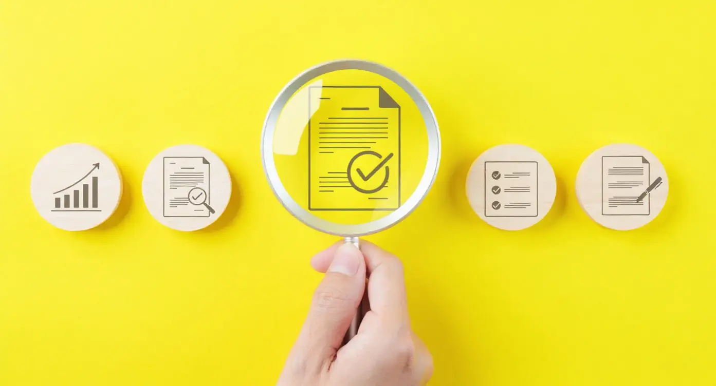 Document avec une coche examiné sous une loupe, sur fond jaune, entouré d'icônes de graphiques et de notes.