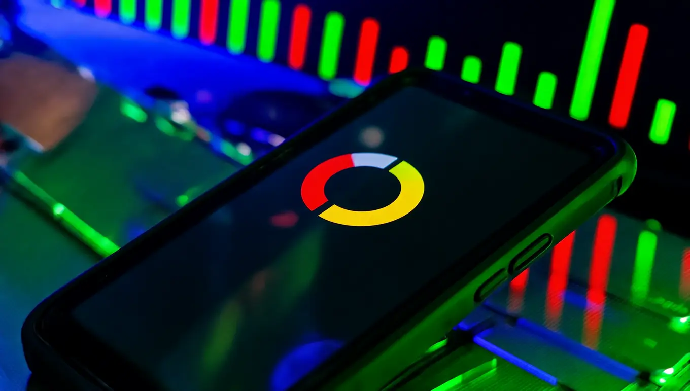 Smartphone affichant un logo coloré sur fond noir avec des lumières LED multicolores en arrière-plan.