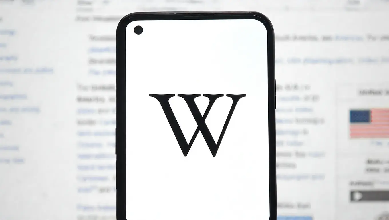 Logo de Wikipedia affiché sur un smartphone, avec un fond flou de pages web.