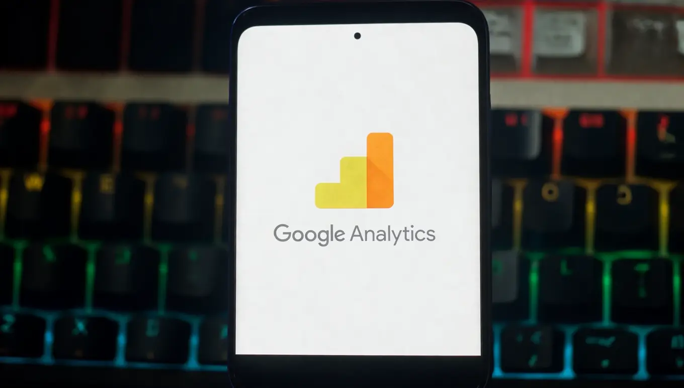 Logo de Google Analytics affiché sur un écran de smartphone avec un clavier coloré en arrière-plan.