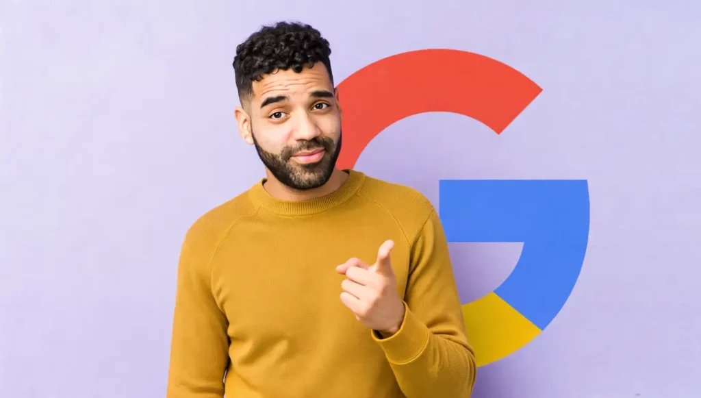 Homme souriant en pull jaune pointant avec un arrière-plan aux couleurs du logo Google.