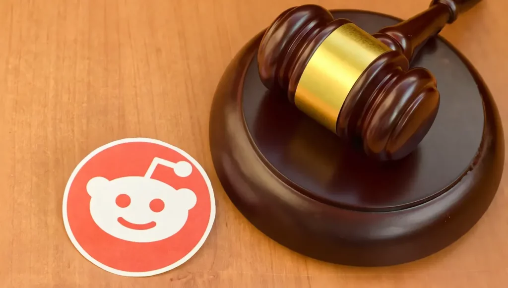 Gavel en bois avec un marteau de juge et un autocollant Reddit sur un fond de table en bois.